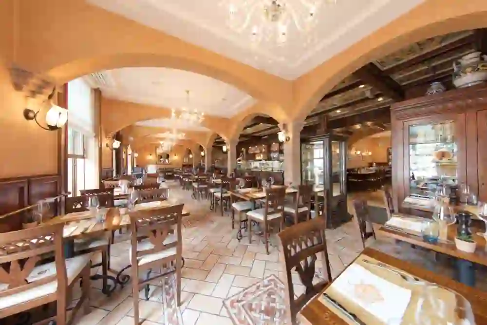 Salle à manger lumineuse et accueillante de style italien avec des lustres, qui dégage une atmosphère de chaleur et d'hospitalité.