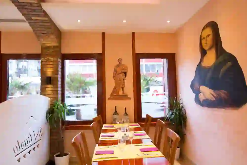 La foto mostra il vivace interno della Pizzeria Del Gusto di Berna, con murales artistici che creano un'atmosfera rilassata e culturalmente ricca.