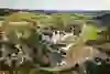 Drone shot of the monastery amidst rolling hills. The expansive view conveys tranquillity, harmony and a generous landscape.
