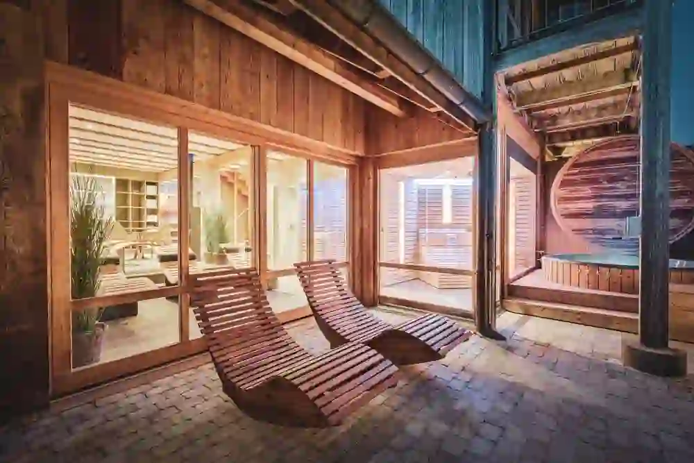 Ein behaglicher Wellnessbereich im Romantikhotel Bären Dürrenroth, wo warmes Licht Ruhe und Entspannung in einer einladenden Holzarchitektur ausstrahlt.