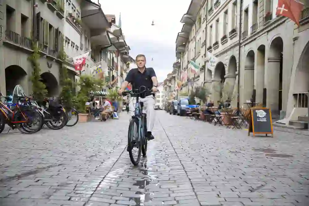The picture is a portrait of Bill Longhurst on his bike in the old town of Bern.