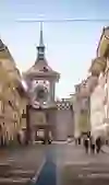 Die historische Straße führt zum Zytglogge, Berns berühmtem Uhrturm, umgeben von flanierenden Menschen und Architektur, die eine lebhafte und zeitlose Eleganz ausstrahlt.