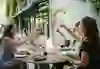 The picture shows a cheerful group of people clinking glasses in an outdoor restaurant. They are smiling and seem to be enjoying each other's company as they sit surrounded by an elegant ambience. The photo conveys an atmosphere of joy and togetherness, perfect for a cosy get-together among friends.