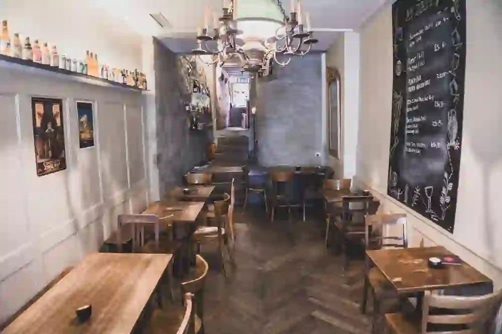 L'interno del pub "Au Trappiste" è invitante e tradizionale, con tavoli in legno e decorazioni classiche. Un'atmosfera tranquilla e accogliente invita a soffermarsi davanti a un buon drink.