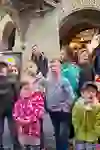 The children look up with excitement while the city guide enthusiastically shows them something in Bern. Their expressive faces reflect their joy and amazement at the newly discovered wonders of the city.