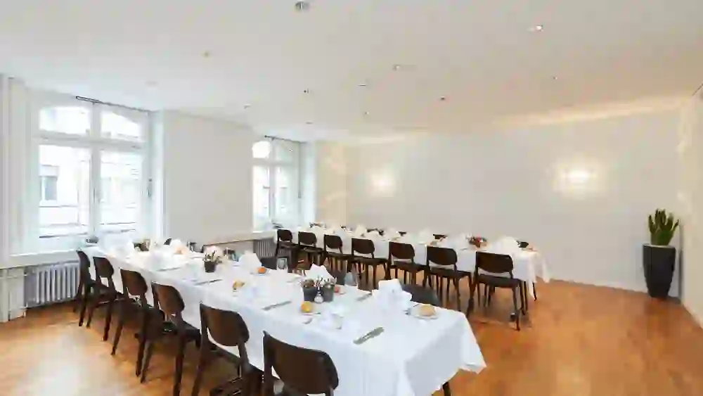 Der Raum strahlt im Licht, während die elegant gedeckten Tische im Kongresszentrum Kreuz Bern auf ein festliches Ereignis warten. Harmonie und Stil gehen hier Hand in Hand, bereit für Erinnerungen, die geschaffen werden sollen.