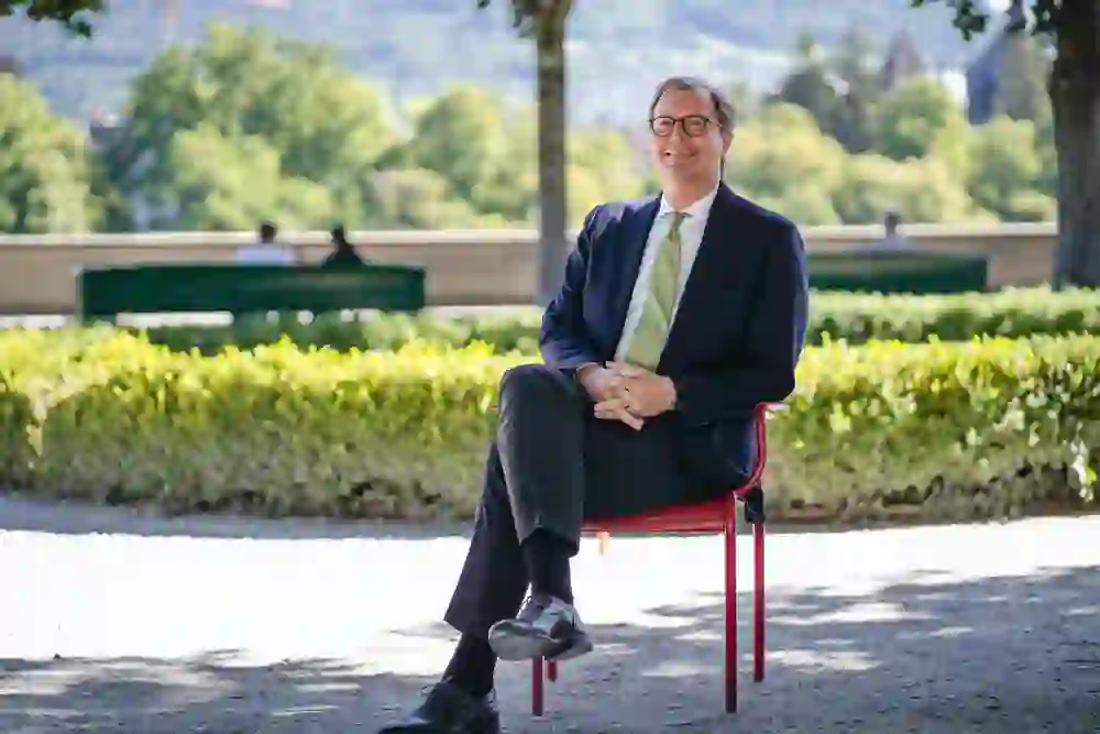 Das Bild ist ein Portrait von Michael Flügger auf der Münsterplattform in der Stadt Bern.