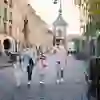 L'immagine mostra una famiglia che cammina lungo una strada di Berna, con la torre Zytglogge sullo sfondo. Sembra che si stiano godendo la giornata.