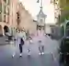L'immagine mostra una famiglia che cammina lungo una strada di Berna, con la torre Zytglogge sullo sfondo. Sembra che si stiano godendo la giornata.