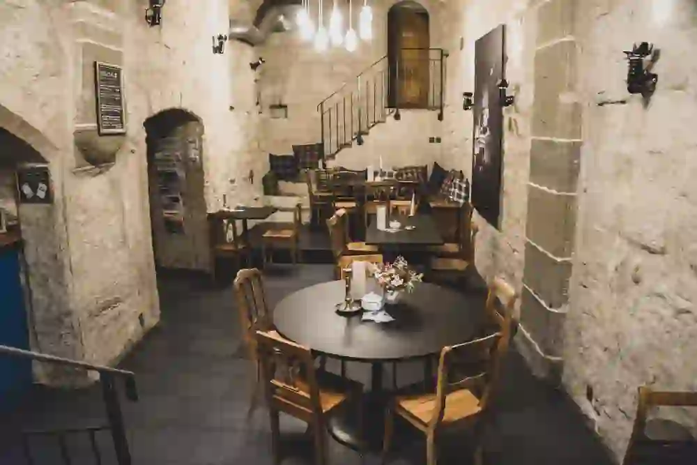 Das Bild zeigt das historische Ambiente der Café Bar Marta mit steinernen Wänden und warmem Licht, das eine gemütliche und einladende Stimmung für ein entspanntes Beisammensein kreiert.
