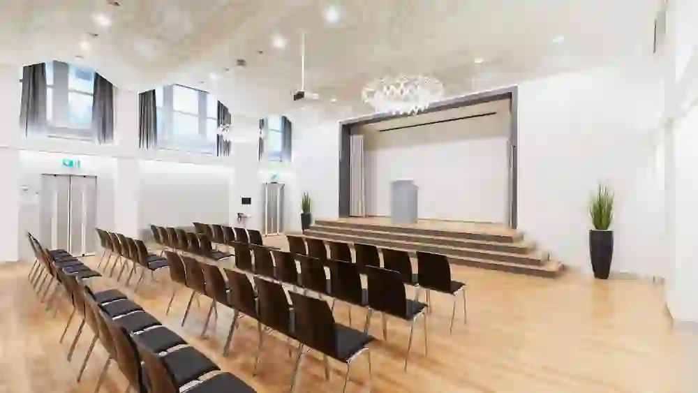 Auf dem Bild ist ein moderner, stilvoller Saal im Kongresszentrum Kreuz Bern zu sehen, ausgestattet für Vorträge oder Konferenzen. Er vermittelt ein Gefühl von Eleganz und Professionalität.