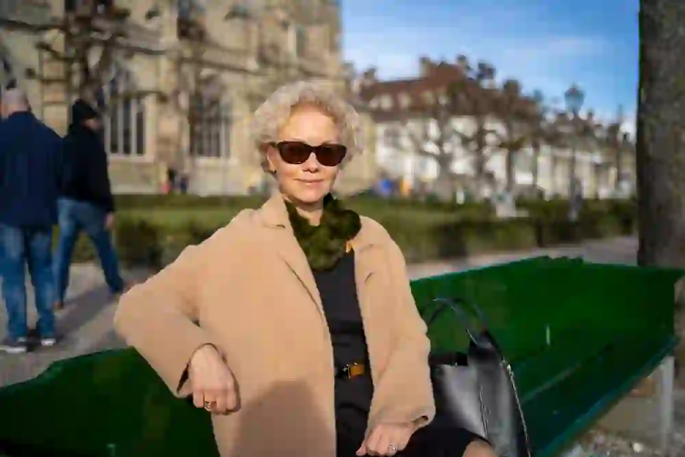 Das Bild ist ein Portrait von Berta Fernández-Alfaro auf einer Bank auf der Münsterplattform.