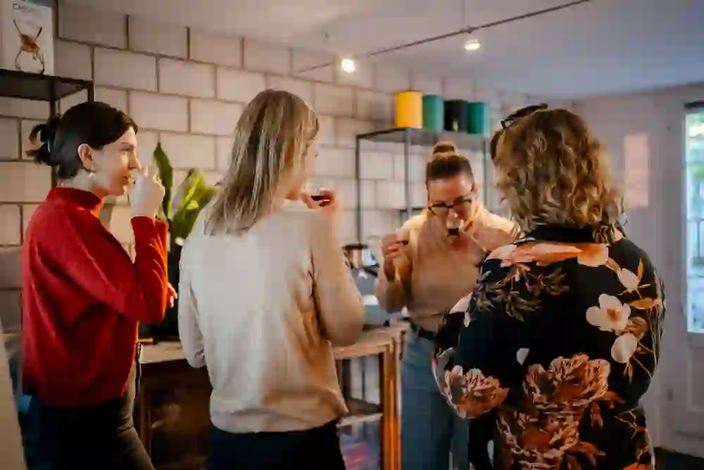 In der gemütlichen Atmosphäre des Coffee Coaching Club geniessen Gäste sichtlich die Verkostung von Kaffee, umgeben von einer einladenden, warmen Einrichtung, die zum Austausch und Genuss einlädt.