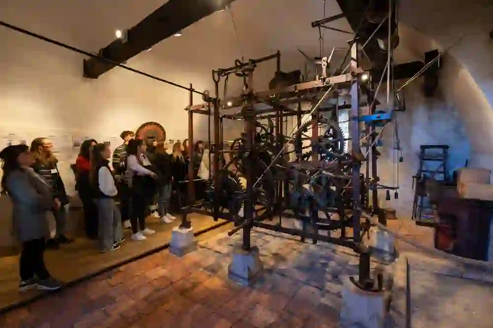 I visitatori ammirano l'antico orologio della Zytgloggeturm, circondati da un fascino storico, con i loro volti che riflettono stupore e curiosità.