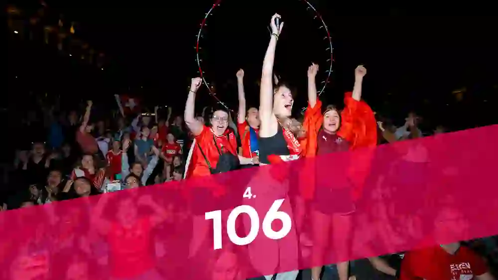 L'image montre un groupe de personnes en liesse sur la Place fédérale lors de la projection publique de l'UEFA Women's Euro 2025.