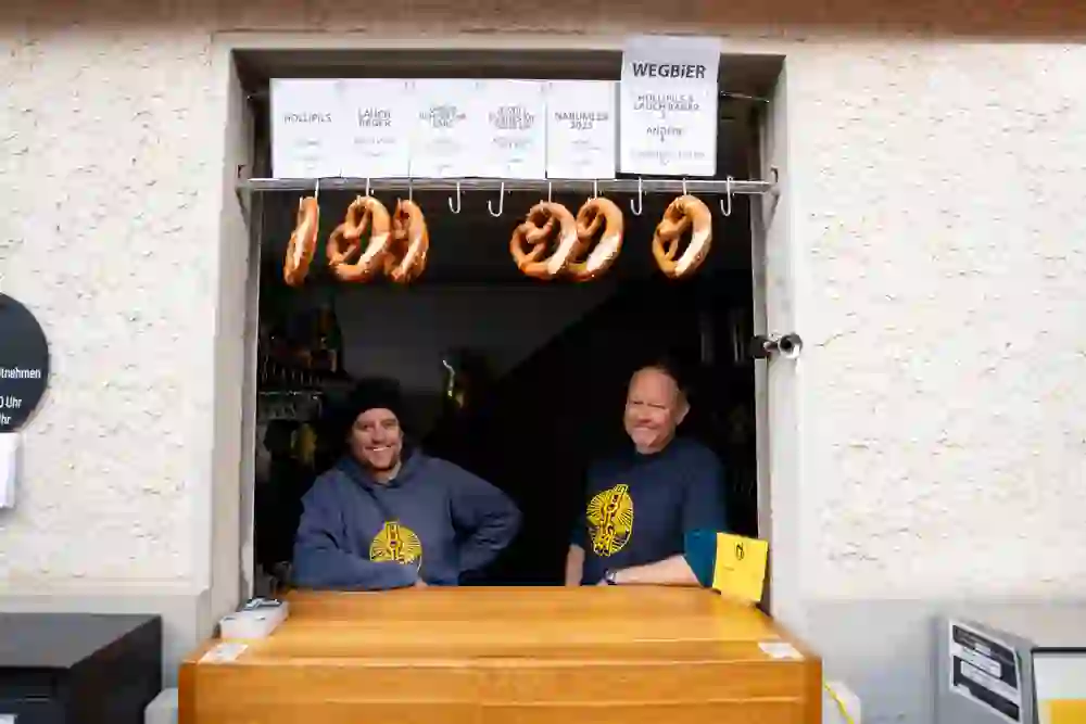Das Foto zeigt die Betreiber der Brauerei Holliger bei ihrem Bierfenster