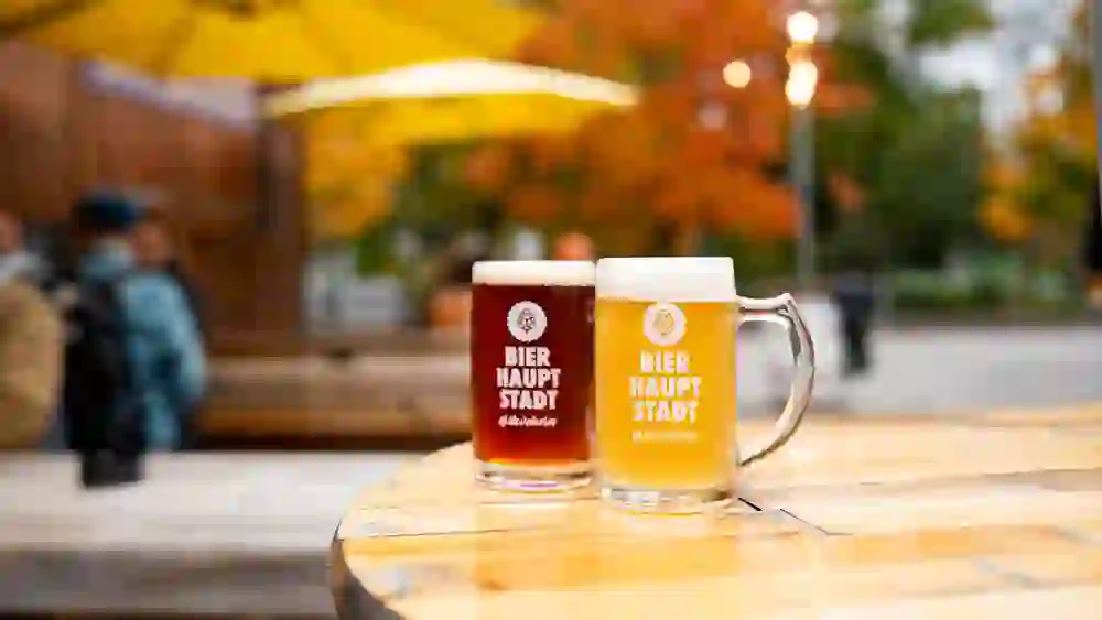 The picture shows two beer capital tankards in autumnal colours on the Bern brewery ice walk