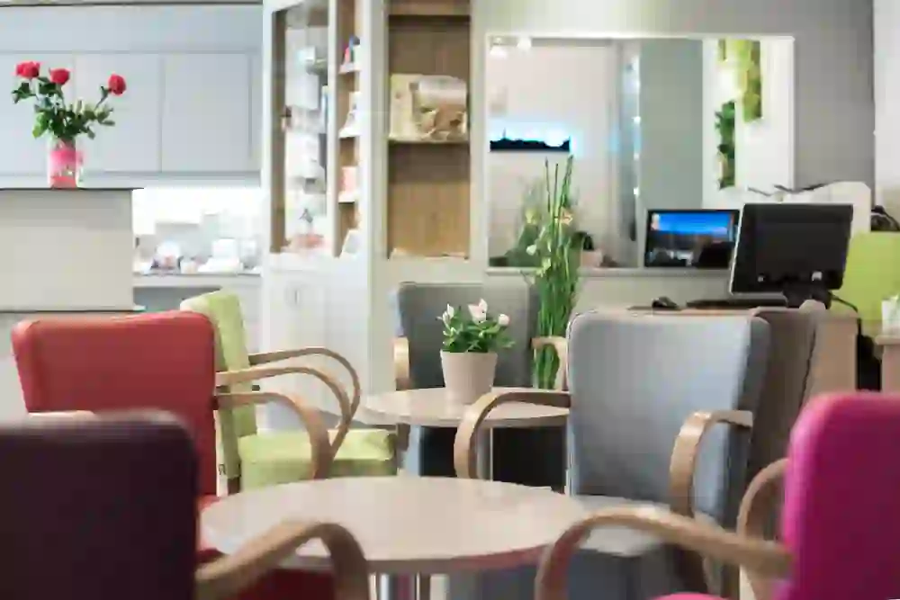 The photo shows a cosy internet corner with colourful armchairs and floral decorations, creating a relaxed and inviting atmosphere.