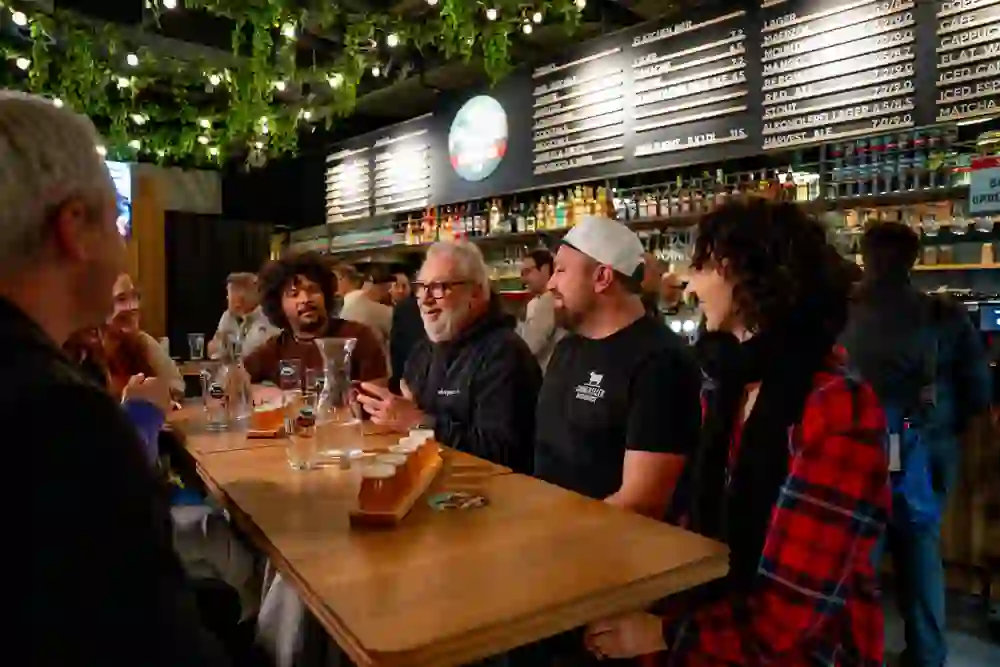 The picture shows a group of people listening with interest to a beer sommelier as part of the city tour Pub Biertour