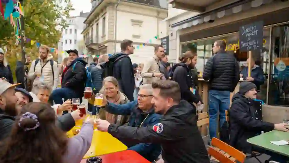 The photo shows visitors to the Bern Brewery Ice Walk 2025 toasting with beer