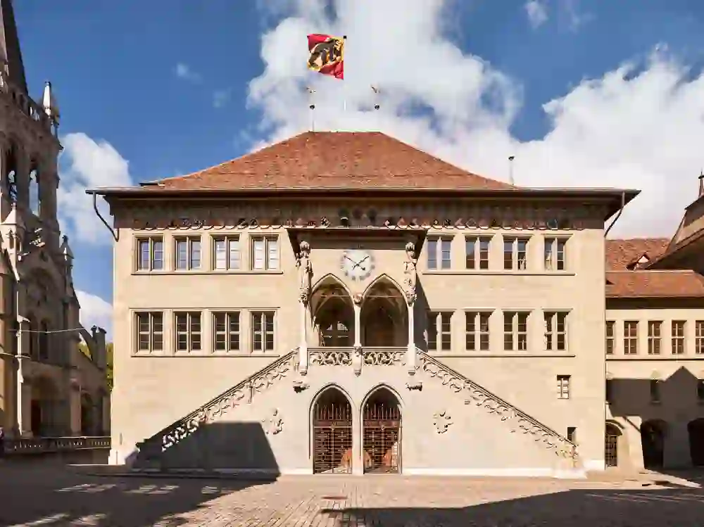 The exterior of Bern City Hall proudly displays its historic architecture and radiates dignity and tradition with its façade and waving flags.