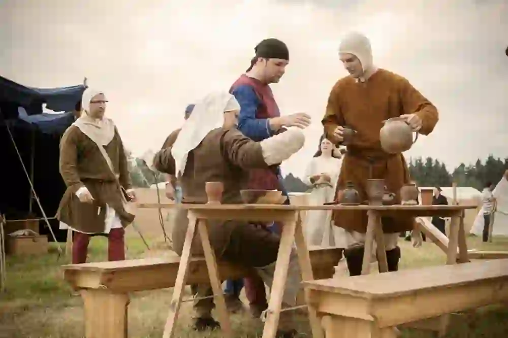 L'image montre une scène qui fait très probablement partie d'un événement de reconstitution médiévale ou d'un marché historique.