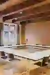 La salle donne une impression de calme, de clarté et de concentration. Les longues rangées de tables en forme de U créent une atmosphère structurée et propice au dialogue - idéale pour les réunions, les ateliers ou les séminaires. Les poutres en bois apparentes au plafond confèrent à la salle chaleur et caractère, tandis que les grandes fenêtres laissent entrer beaucoup de lumière du jour et rendent le contexte historique perceptible. Dans l'ensemble, il en résulte une interaction équilibrée entre fonctionnalité, discrétion et élégance intemporelle.