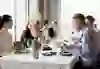 L'immagine mostra un'elegante situazione culinaria nel ristorante UMA Tower. Gli ospiti possono gustare un pasto raffinato in un'atmosfera rilassata e socievole. L'interno è elegante, enfatizzato dalla luce naturale e dalla vista sulla campagna circostante attraverso grandi finestre.