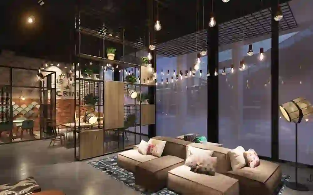 Das Bild zeigt die Lobby des Hotel Moxy Bern Expo, die mit ihrer stilvollen, urbanen Einrichtung und der warmen Beleuchtung eine einladende und trendige Atmosphäre schafft.