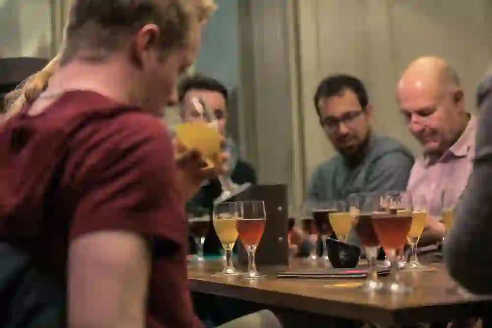 Das Bild von der Berner Biertour zeigt eine Gruppe von Personen, die sich entspannt bei Bierproben unterhält – eine Atmosphäre der Geselligkeit und des Genusses.