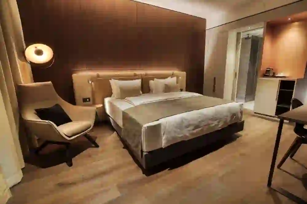 The photo shows a stylishly furnished hotel room in the Hotel Meilenstein with warm wood tones and soft lighting, creating a cosy and luxurious atmosphere.