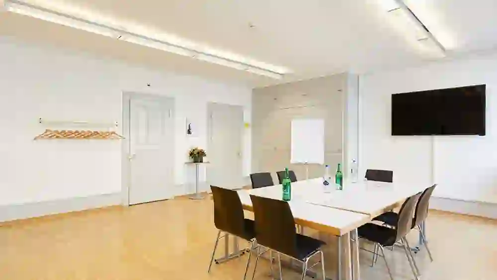 Der Tagungsraum im Kongresszentrum Kreuz Bern strahlt mit seiner schlichten Eleganz und hellen Beleuchtung eine Atmosphäre von Klarheit und Professionalität aus, ideal für fokussierte Diskussionen und produktive Zusammenkünfte.