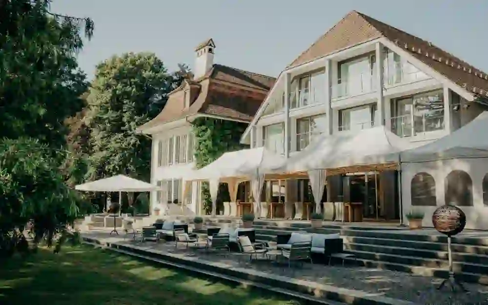 Le château de Hünigen, entouré d'un jardin soigneusement entretenu avec des arbres ombrageux et des sièges relaxants, invite au calme et au repos dans une atmosphère élégante.
