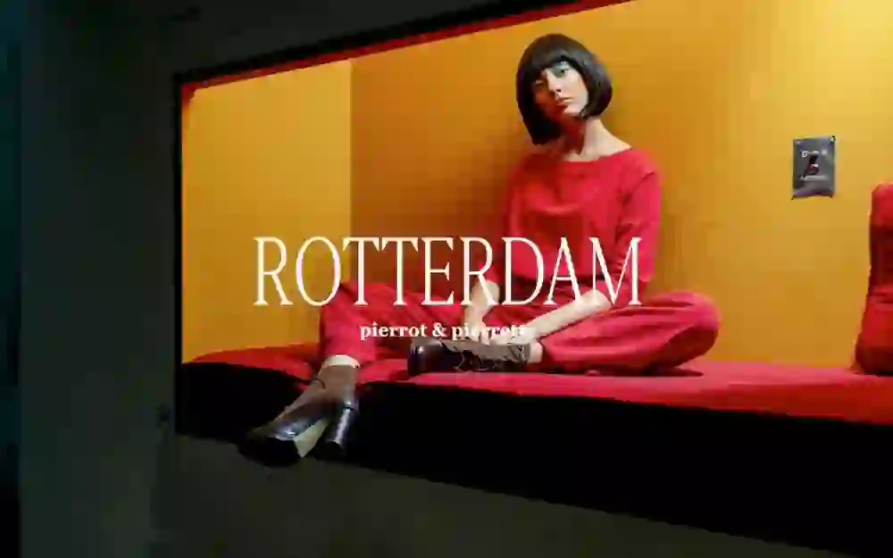 The person in the picture presents herself confidently and stylishly in a red ensemble, which is emphasised by the golden background. Her pose and direct gaze into the camera radiate calm determination.