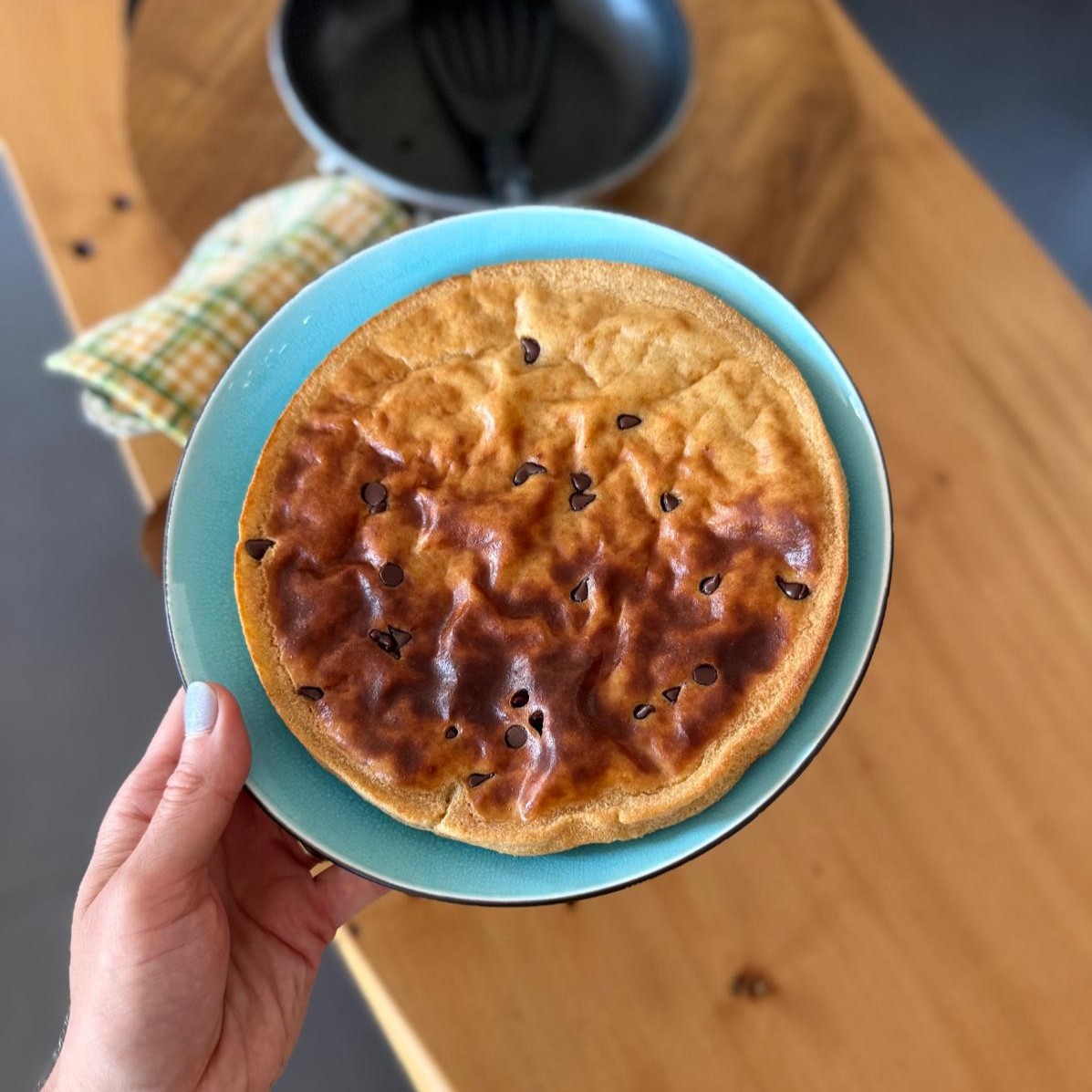 A high-protein one-pan pancake on a blue plate with chocolate chips, made with cottage cheese and Greek yogurt for a gestational diabetes breakfast.