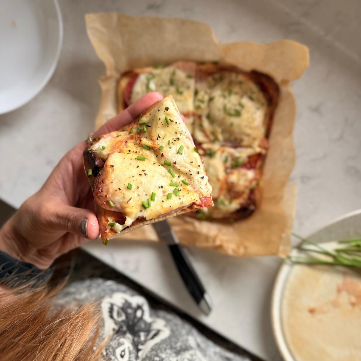 A slice of high-protein breakfast pizza topped with cheese and herbs, made with cottage cheese and eggs for a gestational diabetes-friendly breakfast.