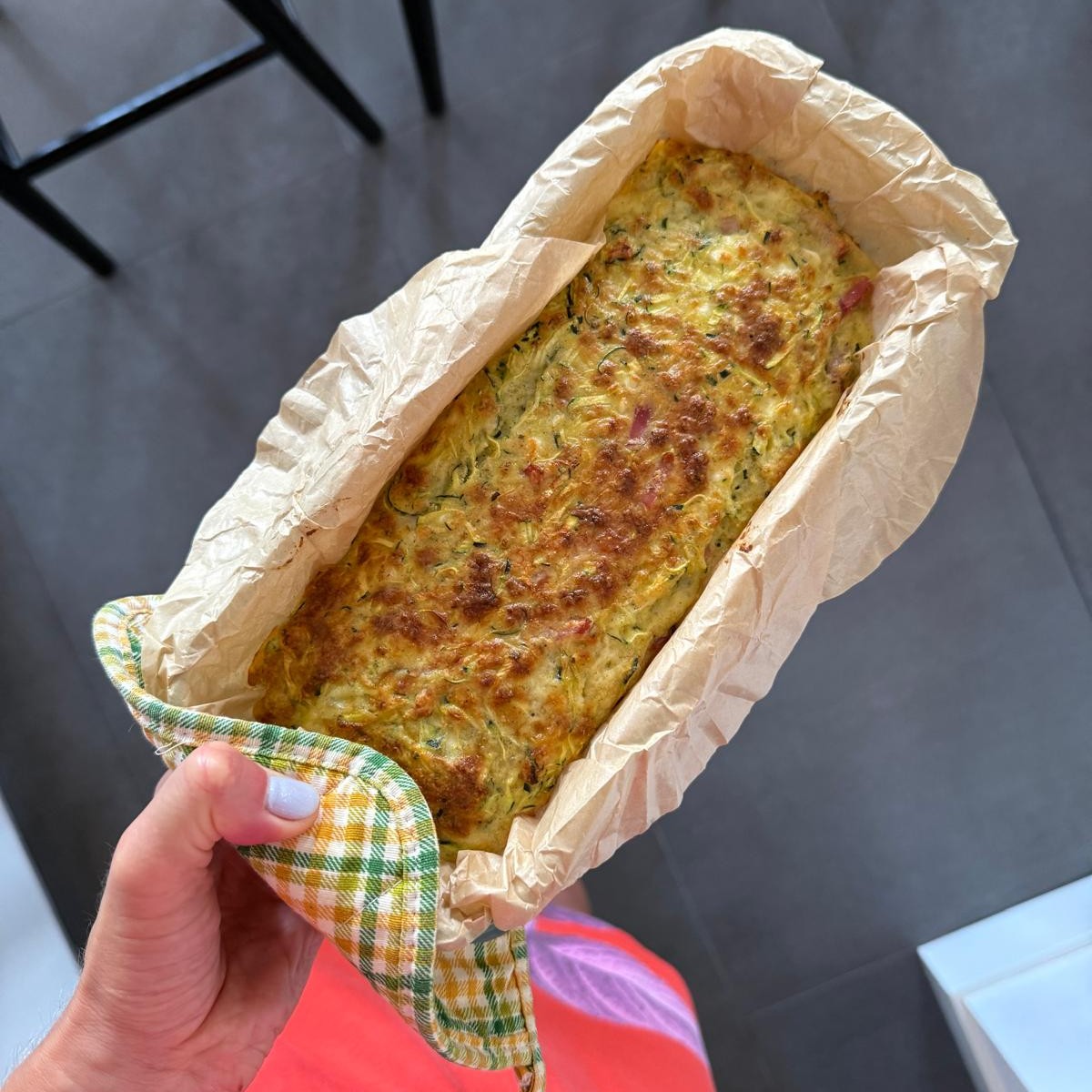 High-protein gestational diabetes breakfast photo of a zucchini breakfast slice baked in a loaf pan lined with parchment paper.