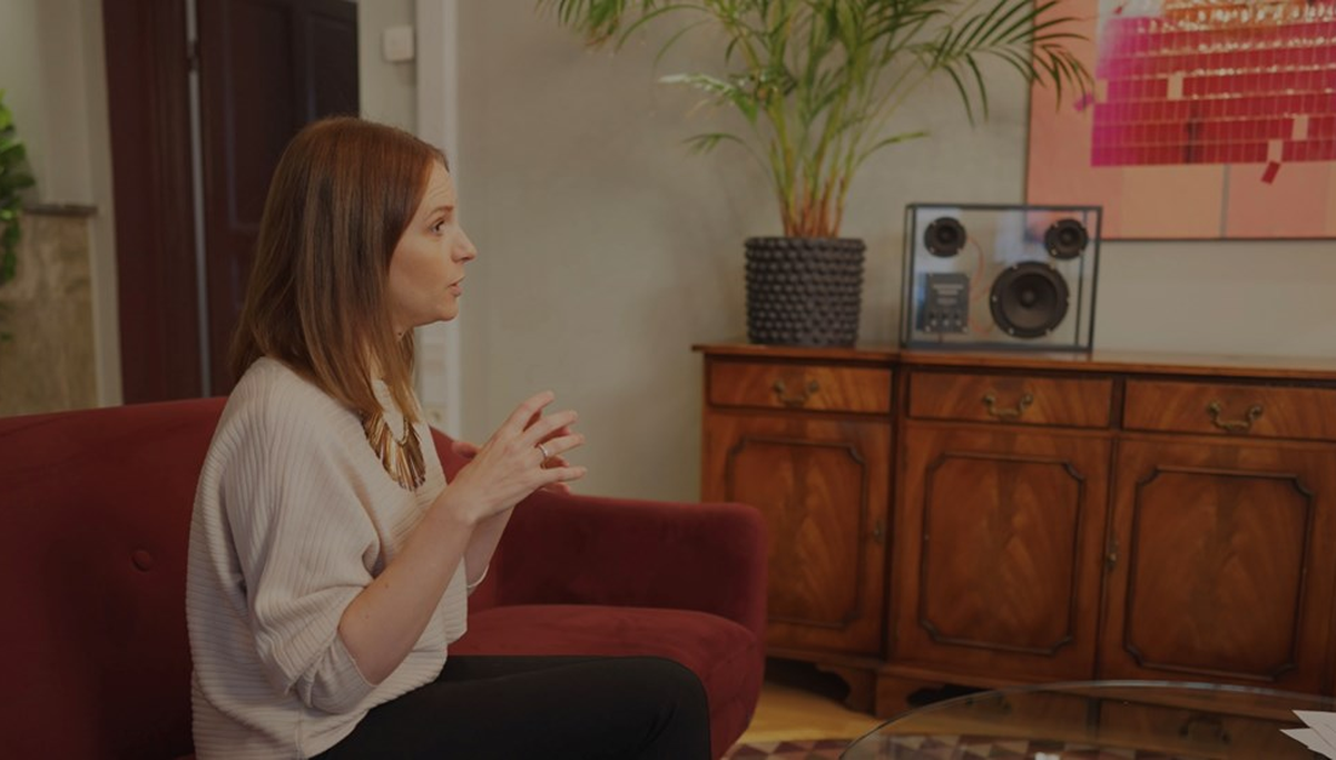 Sandra Bourbon sitter i profil i en soffa och blir intervjuad.