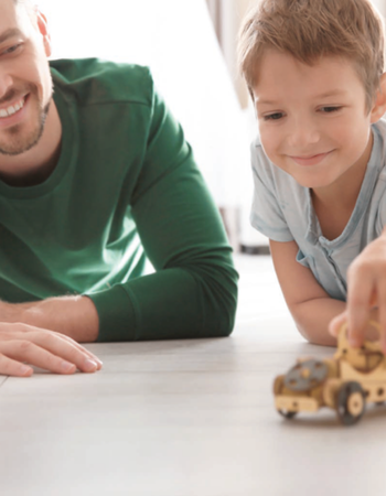 Mann und Junge spielen am Boden