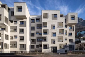 View of buildings on Via Aslago, showing the new top floor vertical extension, and the new facade's recessed window surround details in contrasting grey render finishes
