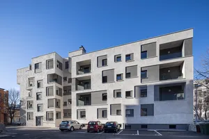 View of the side of the buildings on Via Aslago, Bolzano, Italy, showing the new facade's window details in contrasting grey render finishes, and new balconies and loggias