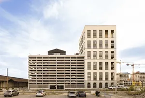 Multi-storey parking structure next to a modern residential and office building