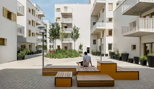 Wohnhäuser des Stadtquartiers Rivus Vivere von außen, mit Sitzgelegenheiten