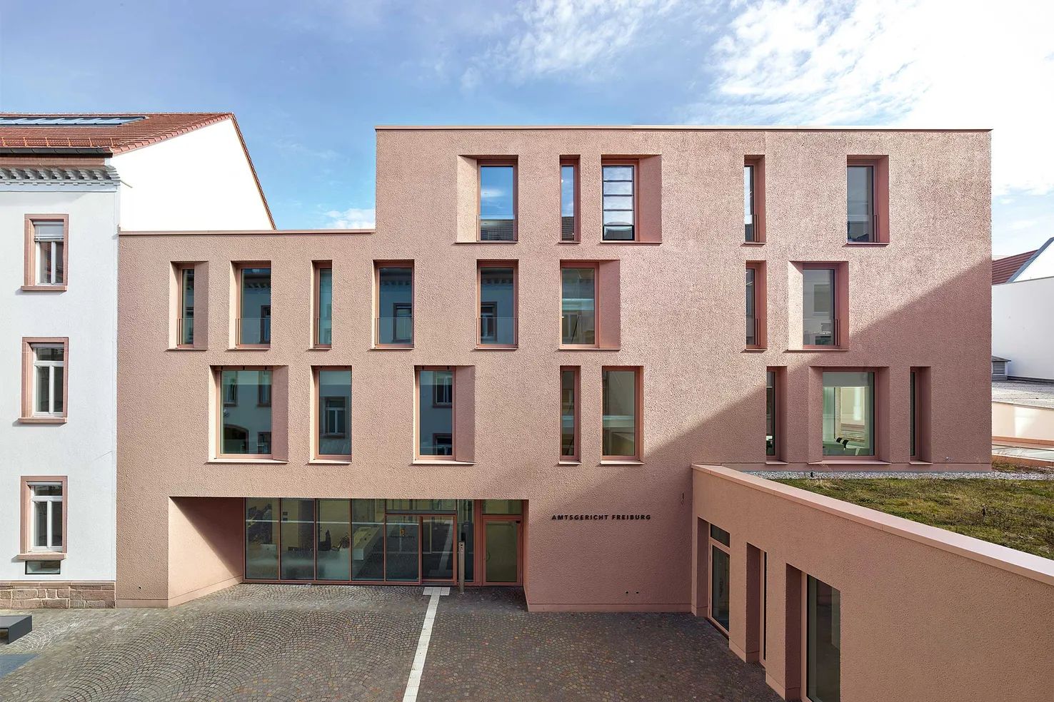 Erweiterungsbau des Amtsgerichts Freiburg mit porphyrroter Putzfassade auf StoVentec R