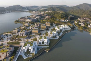Dongqian Lake Club Houses: Fünf weiße Wohnhäuser am Seeufer, ein Museum mit schwarzer Fassade im Hintergrund.