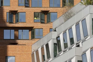 Backsteinfassade eines Wohngebäudes und Metallfassade eines Bürogebäudes