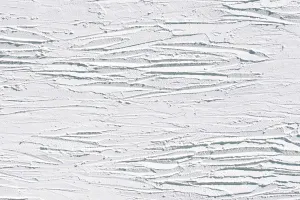 Closeup eines weißen Putzmuster mit Schatten im Querformat