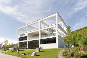 Modern white museum building of the Schütz Art Museum in Engelhartszell, featuring an open frame structure and large glass façades.