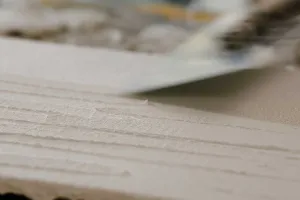 Closeup eines weißen Putzmuster mit Schatten im Querformat