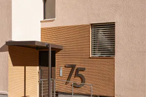 Renoviertes Wohngebäude mit hellen Fassaden, Balkonen und modernisierten Architekturdetails.